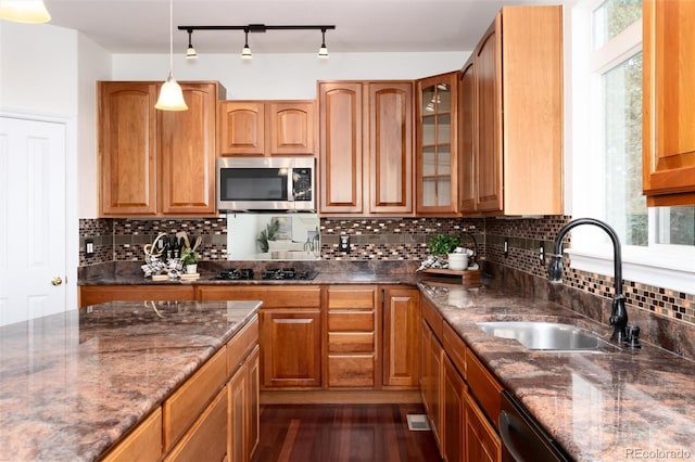 kitchen featuring pendant lighting, dark wood-type flooring, sink, dark stone countertops, and black electric cooktop