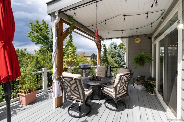 wooden terrace with area for grilling and a fire pit