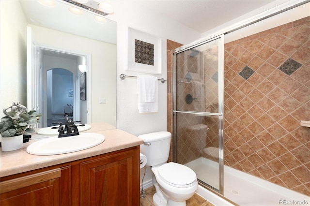 bathroom featuring vanity, toilet, and an enclosed shower