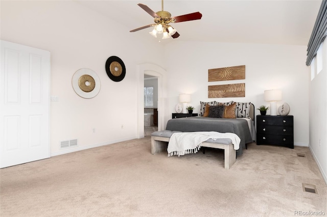 carpeted bedroom with ceiling fan, ensuite bathroom, and lofted ceiling