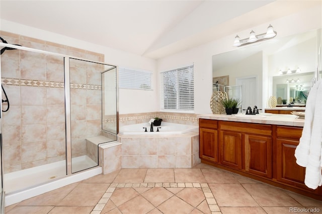 bathroom featuring vanity, separate shower and tub, vaulted ceiling, and tile patterned flooring