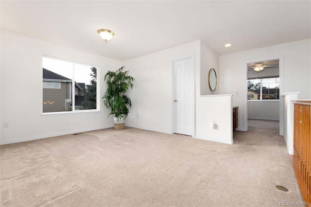 spare room featuring ceiling fan and light colored carpet