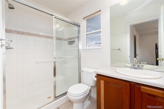 bathroom with tile patterned flooring, vanity, toilet, and walk in shower