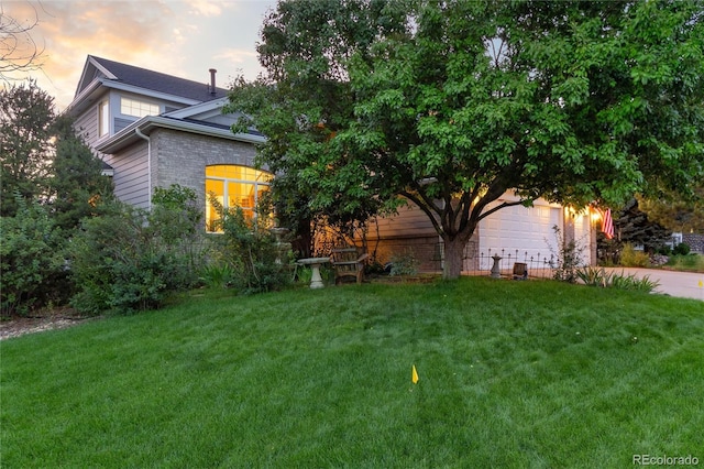 exterior space featuring a garage and a lawn