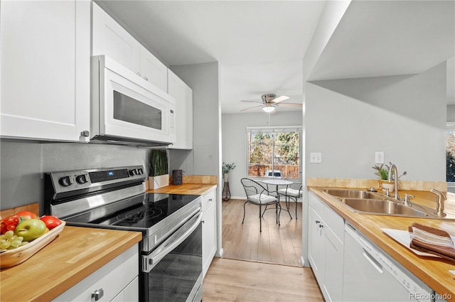 kitchen with ceiling fan, white cabinets, light hardwood / wood-style floors, and white appliances