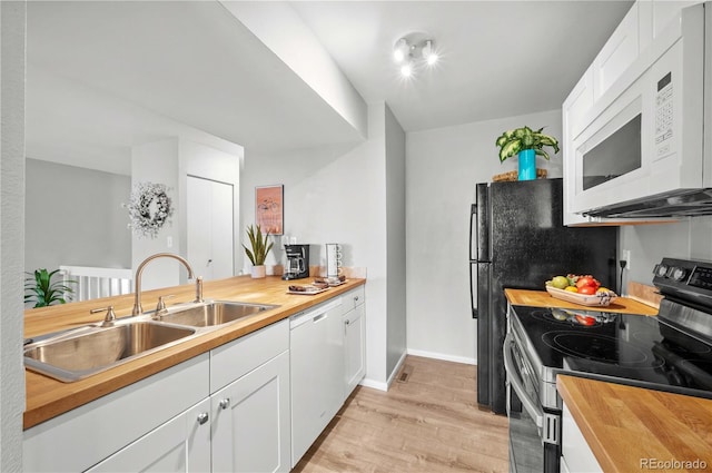 kitchen featuring wood counters, white appliances, sink, white cabinets, and light hardwood / wood-style floors