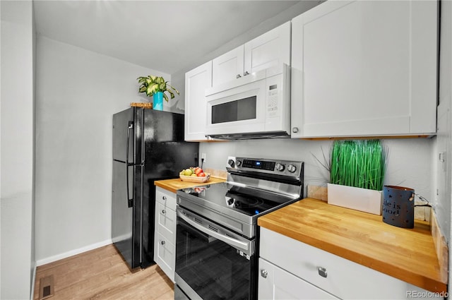 kitchen with white cabinetry, black fridge, electric range, and light hardwood / wood-style floors