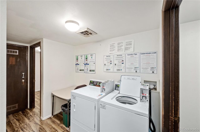 laundry room featuring washer and dryer, wood-type flooring, and a textured ceiling