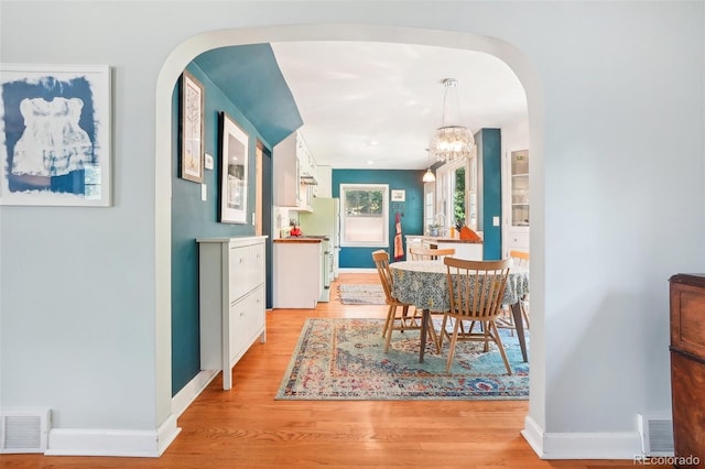 1100 W Mulberry St, Fort Collins, CO 80521 - dining space with visible vents, arched walkways, baseboards, light wood finished floors, and an inviting chandelier