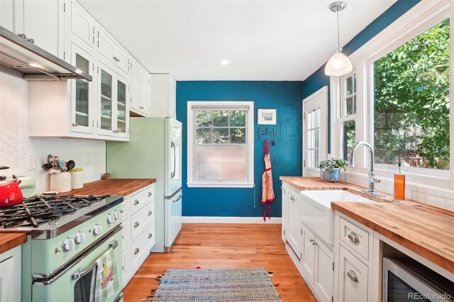 1100 W Mulberry St, Fort Collins, CO 80521 - kitchen with range with gas stovetop, butcher block counters, light wood-type flooring, white cabinetry, and a sink