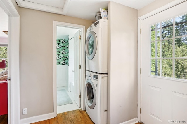 1100 W Mulberry St, Fort Collins, CO 80521 - washroom featuring stacked washer and dryer, laundry area, a healthy amount of sunlight, and light wood-style floors