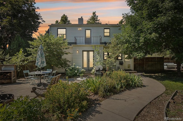 1100 W Mulberry St, Fort Collins, CO 80521 - back of house at dusk featuring fence, a chimney, a patio area, and a balcony