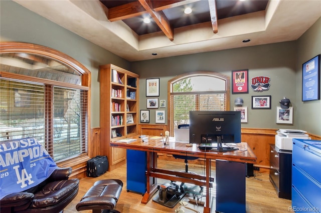 home office with beamed ceiling, coffered ceiling, and light hardwood / wood-style flooring