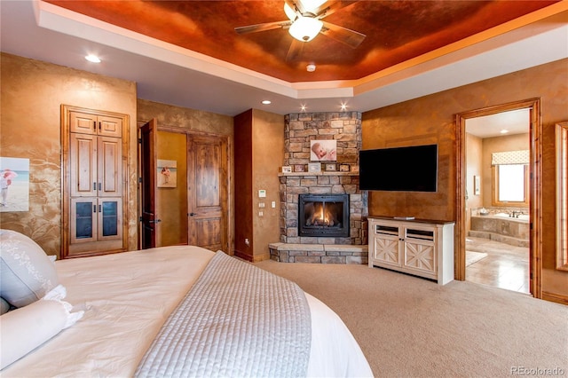 bedroom featuring a fireplace, carpet flooring, and a raised ceiling