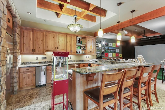 kitchen with a kitchen bar, decorative light fixtures, kitchen peninsula, and dark stone counters