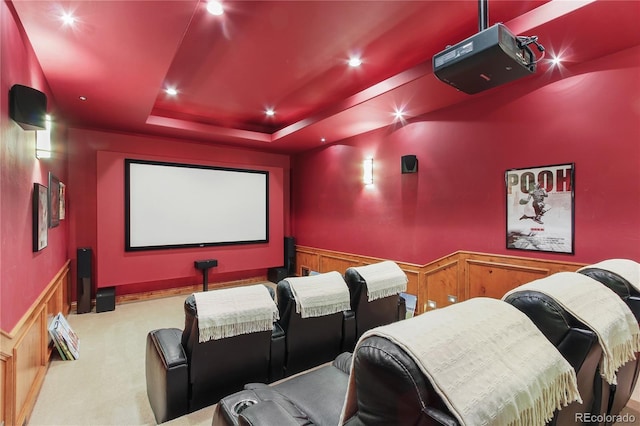 carpeted cinema featuring a raised ceiling