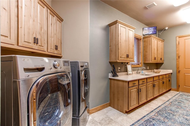 clothes washing area featuring cabinets, independent washer and dryer, sink, and light tile patterned floors