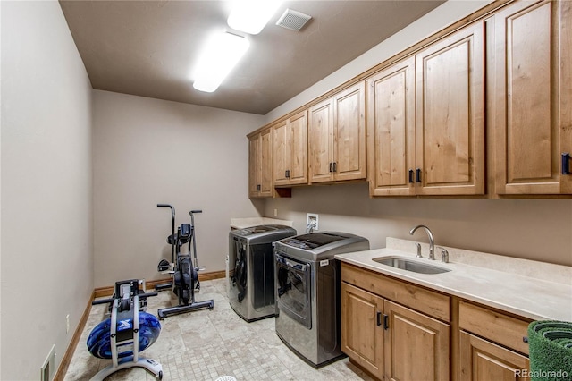 laundry room with independent washer and dryer, cabinets, and sink