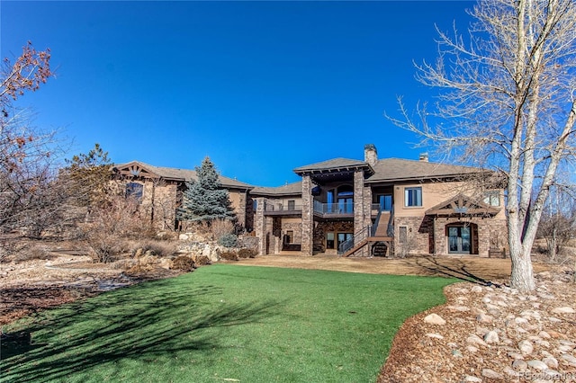 back of property with a yard, a patio, and a balcony