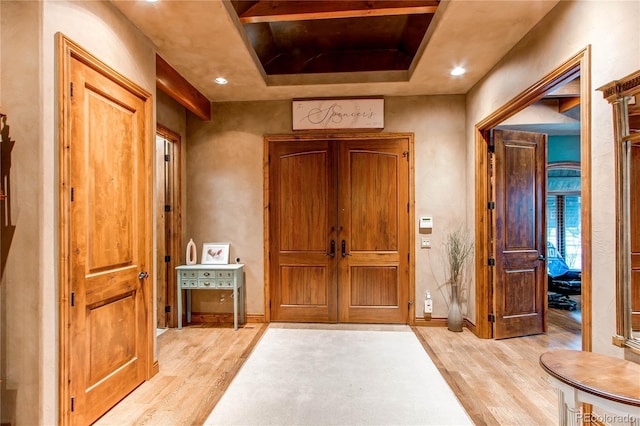 interior space with light wood-type flooring and a tray ceiling