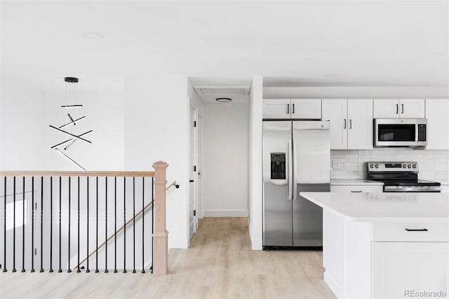 kitchen with stainless steel appliances, light wood-style floors, light countertops, backsplash, and baseboards