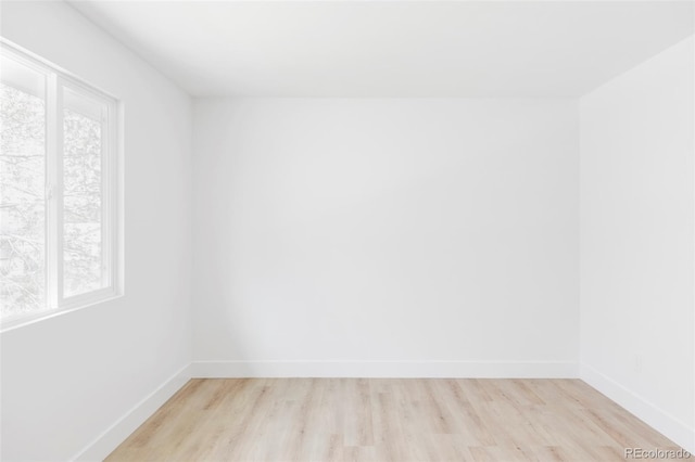 spare room featuring light wood-style floors and baseboards
