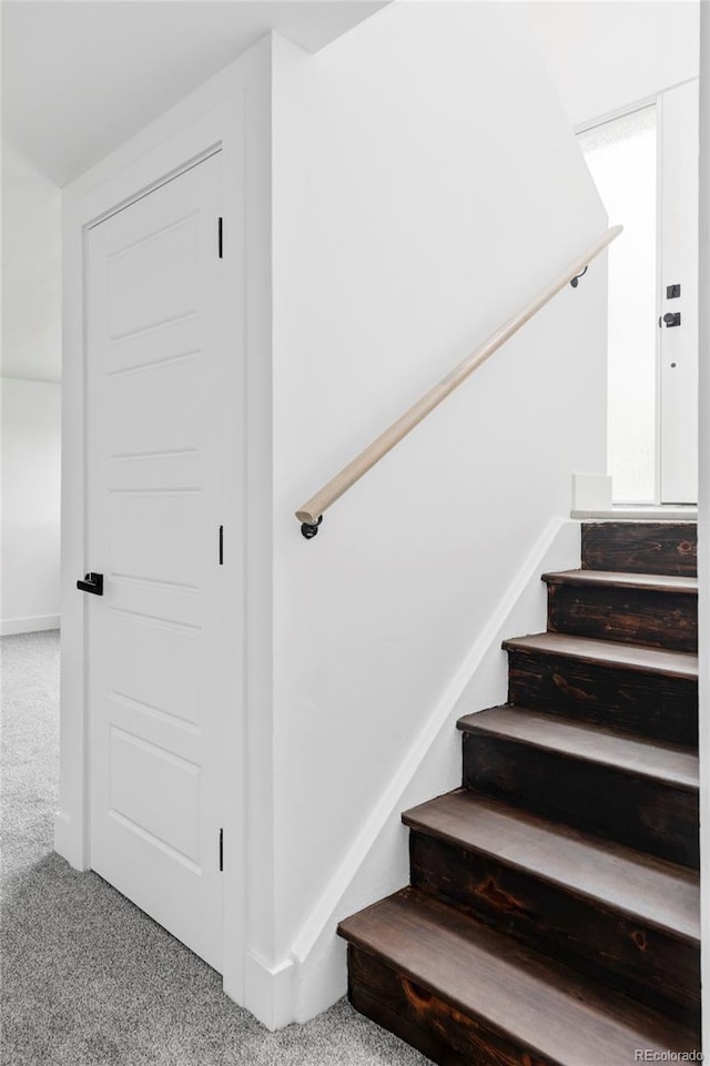 staircase featuring carpet floors and baseboards