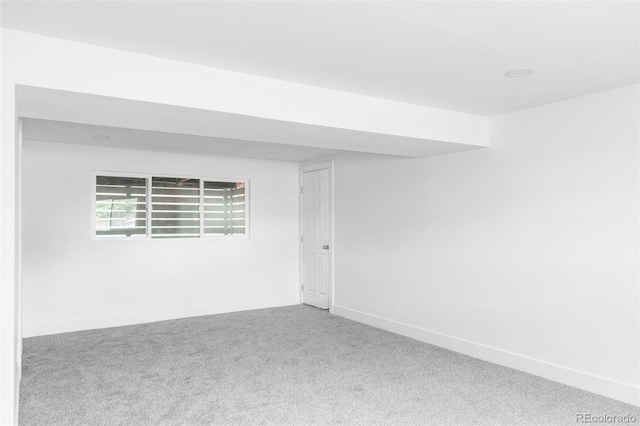 spare room featuring carpet floors and baseboards