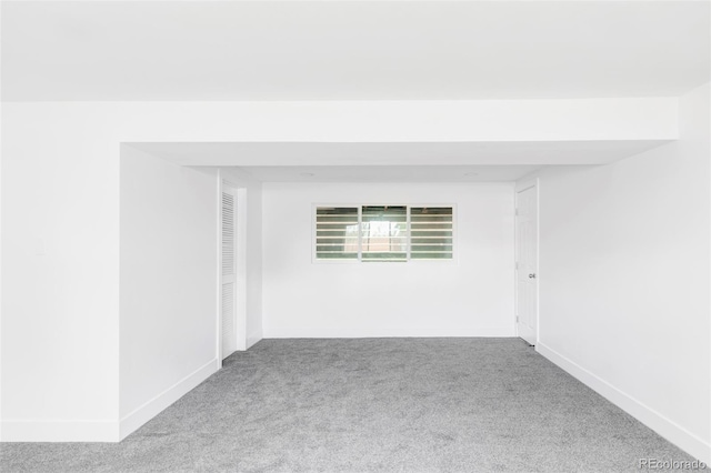 carpeted spare room featuring baseboards