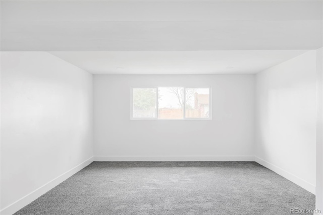 spare room featuring carpet and baseboards