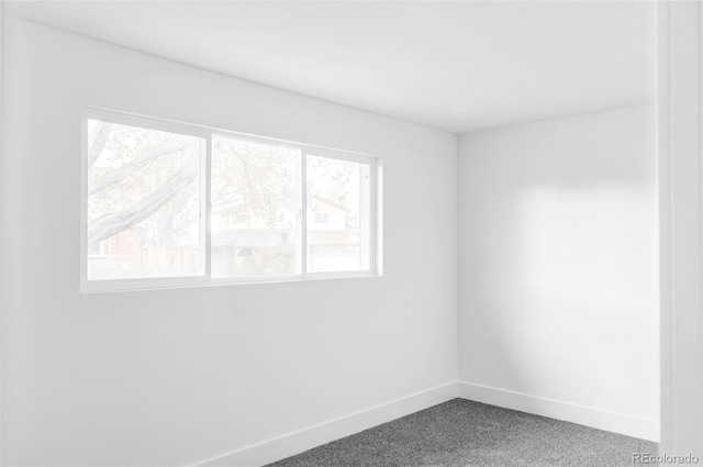 carpeted spare room with baseboards