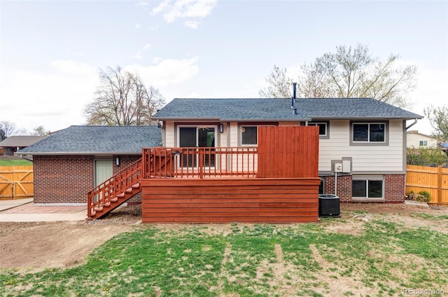 rear view of house with stairway, fence, brick siding, and a wooden deck