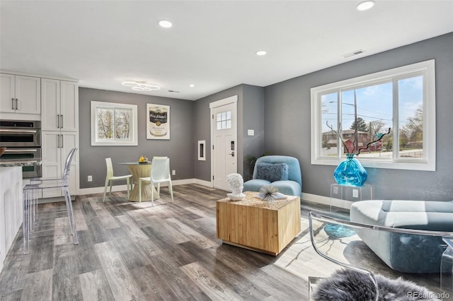 living room featuring a wealth of natural light, visible vents, and recessed lighting