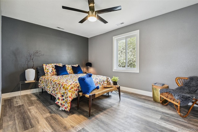 bedroom featuring baseboards, visible vents, and wood finished floors