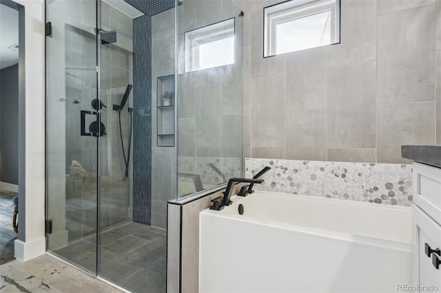 full bathroom featuring a garden tub and a shower stall