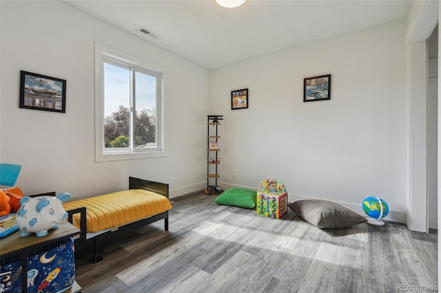 sitting room with baseboards, visible vents, and wood finished floors
