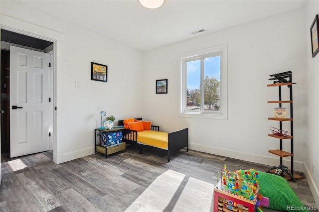 interior space featuring visible vents, wood finished floors, and baseboards