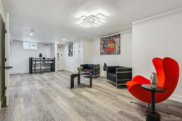 sitting room featuring visible vents, light wood-style flooring, baseboards, and recessed lighting