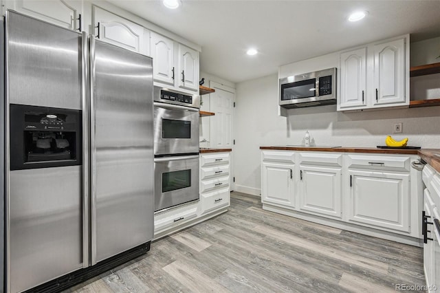 kitchen with light wood-style floors, stainless steel appliances, open shelves, and white cabinets