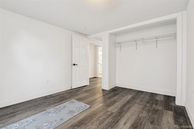 unfurnished bedroom featuring baseboards, a closet, and wood finished floors