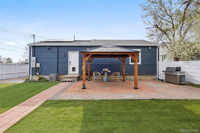 back of house featuring a patio area, a gazebo, a lawn, and fence