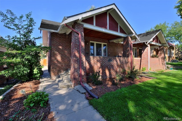 view of front of house featuring brick siding and a front yard