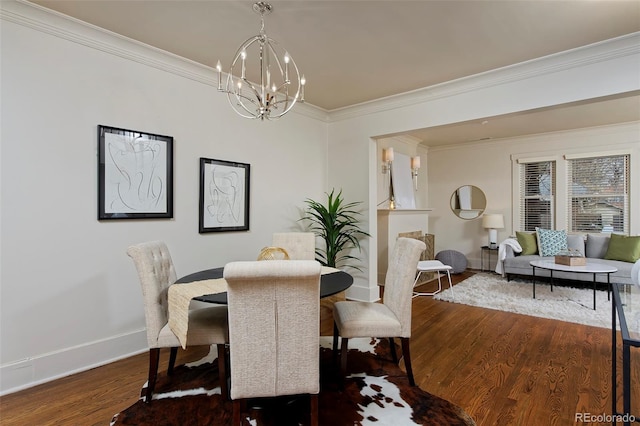 dining space with ornamental molding, baseboards, an inviting chandelier, and wood finished floors