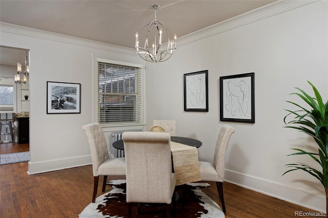 dining room featuring ornamental molding, a notable chandelier, baseboards, and wood finished floors