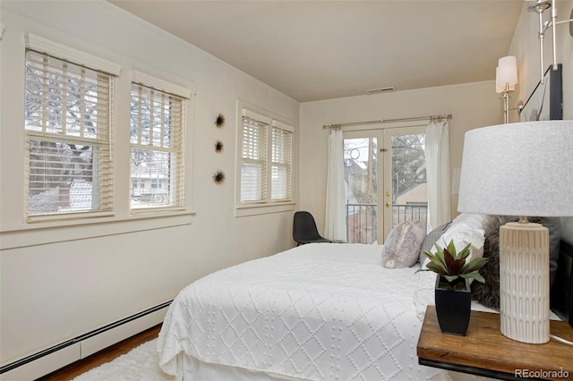 bedroom featuring access to exterior, french doors, visible vents, a baseboard heating unit, and wood finished floors