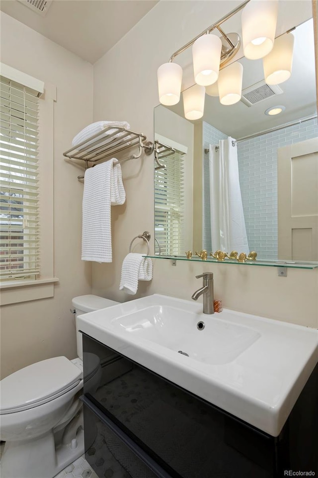 full bath featuring toilet, curtained shower, visible vents, and vanity