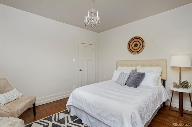 bedroom featuring an inviting chandelier, wood finished floors, and baseboards