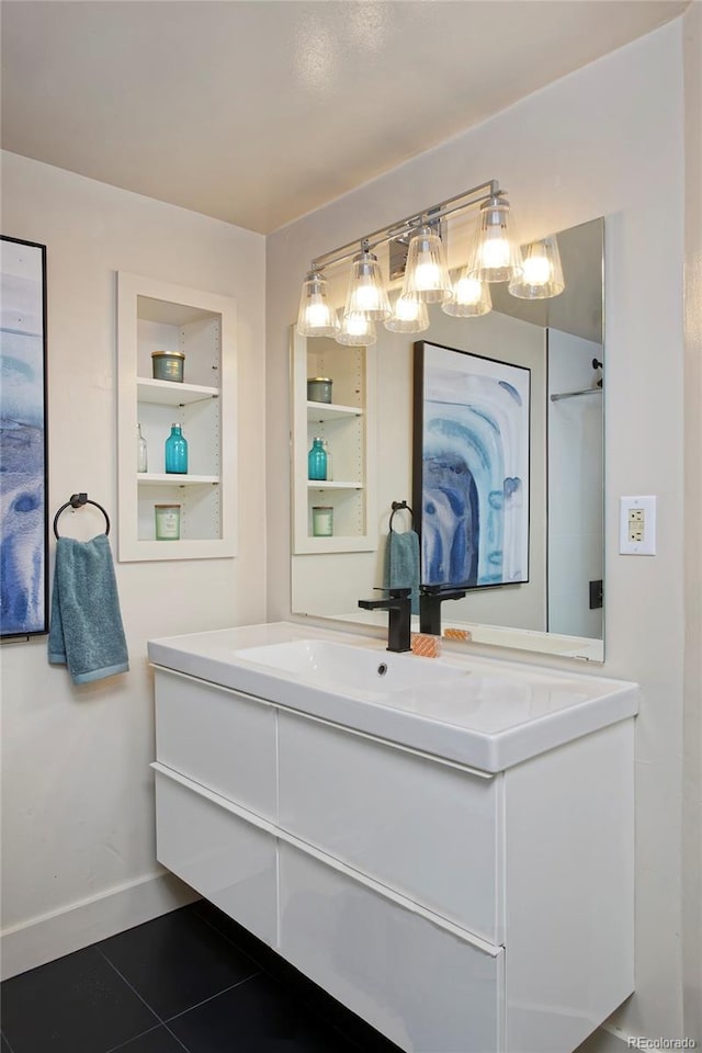 full bathroom featuring tile patterned floors, built in shelves, baseboards, and vanity