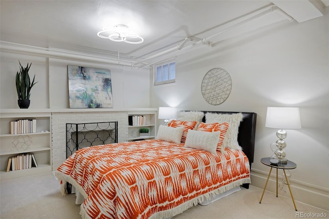 bedroom with a brick fireplace and carpet flooring