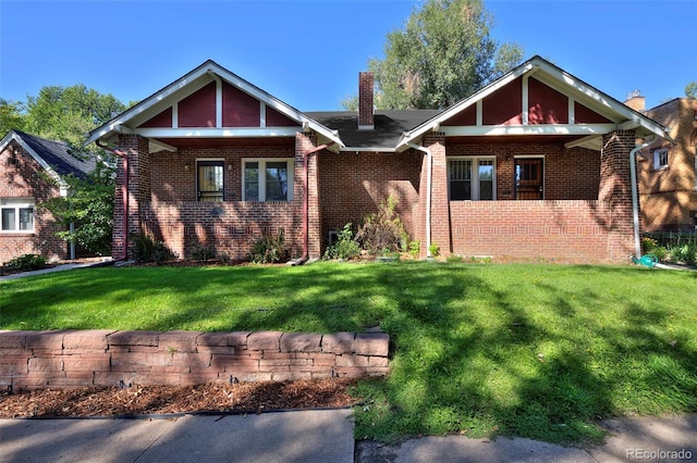 view of front of home with brick siding, a chimney, and a front lawn